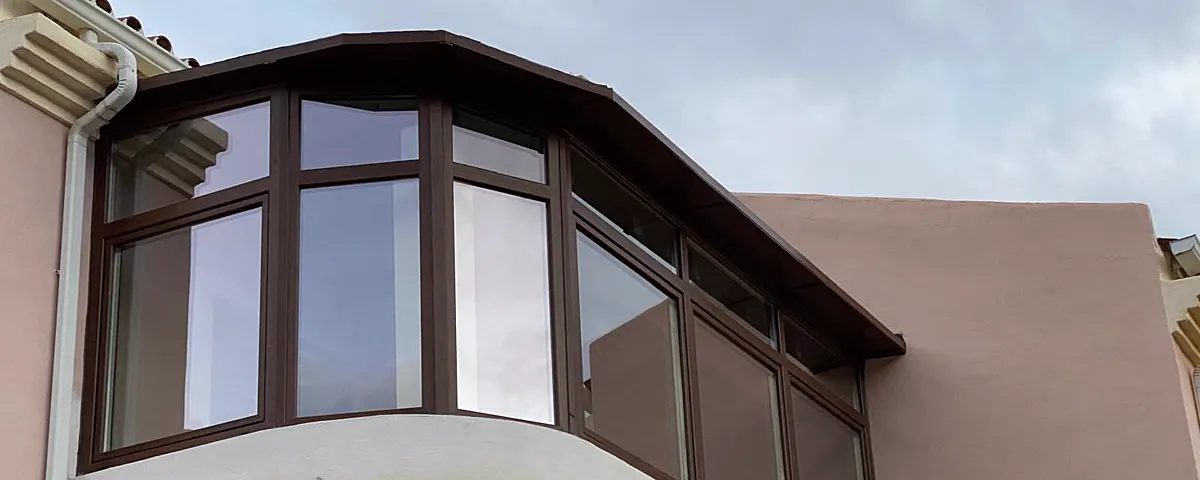 Mirador acristalado en acabado imitación madera en la fachada de una vivienda