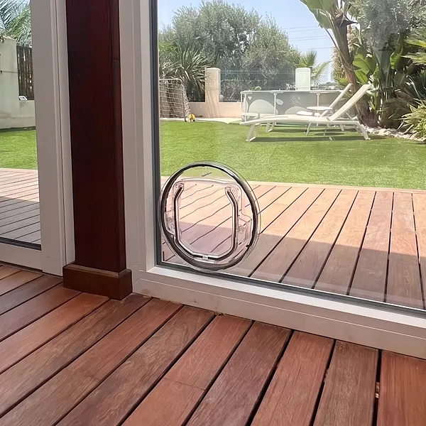 Detalle del umbral de una puerta corredera de aluminio con gatera integrada en el vidrio