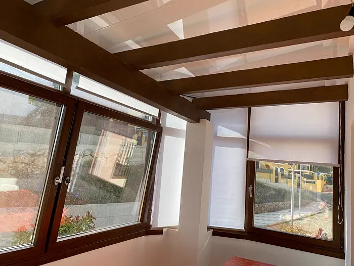 Ventanas en acabado imitación madera bajo un techo de vigas